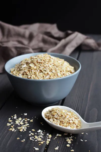 Seramik kase ve doku ile koyu ahşap masa kaşık haddelenmiş yulaf