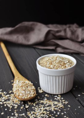 Kase ve koyu ahşap masa kaşık haddelenmiş yulaf