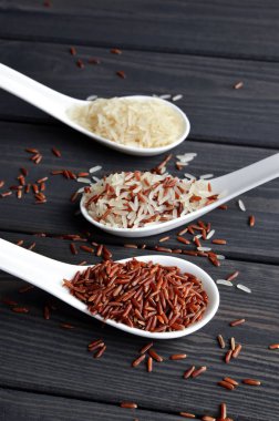 Ahşap masa arka planda kaşık pirinç farklı türleri