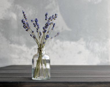 Lavanta çiçekleri koyu renkli masada cam sürahide.