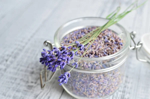 Bir buket lavanta ve kurutulmuş lavanta çiçekleri cam kavanozda yakın plan çekimde.