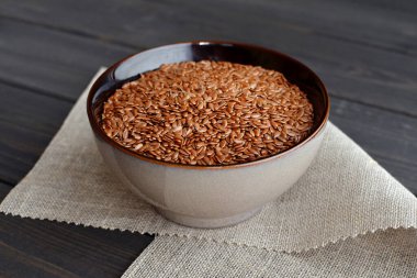 ahşap arka plan üzerinde keten kumaş ile kase keten tohumu