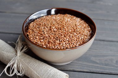 ahşap arka plan üzerinde keten kumaş ile kase keten tohumu