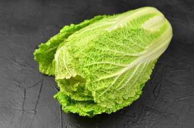 Siyah grunge arka planda Çin lahanası kafası. Vegan eko-bilinçli gıda konsepti.