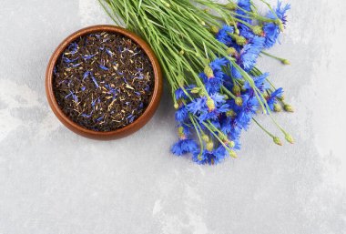 Siyah çay, kurutulmuş mısır çiçeği yaprakları kekik ve taze mavi çiçek demeti karışımı. Üst görünüm, alanı kopyala