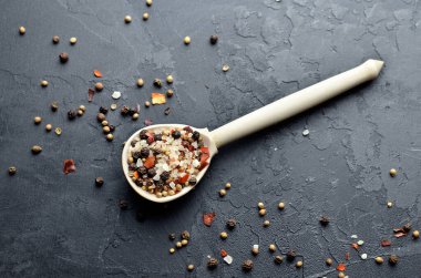Baharat, arka planda ahşap kaşıkla harmanlanır. Biber, deniz tuzu, kardamon, hardal tohumu ve kırmızı biber. Üst Manzara. Yemek malzemeleri fotoğrafçılığı