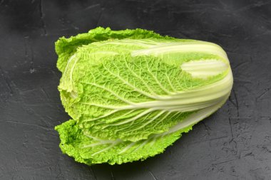 Siyah arka planda yeşil Çin lahanası başı. Vegan eko-bilinçli gıda konsepti.