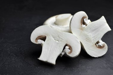 Siyah arka planda kesilmiş şampiyon mantarları. Vejetaryen gıda konsepti.