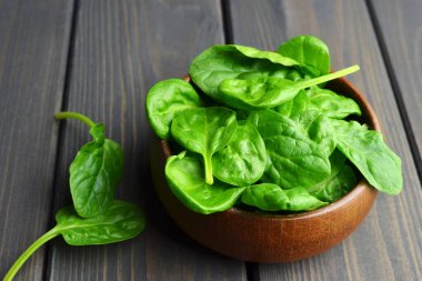 Tahta kasedeki taze ıspanak yaprakları eski ahşap masanın üzerinde. Sağlıklı vejetaryen yemeği. Yeşil yaşam ve çevre bilinci kavramı.