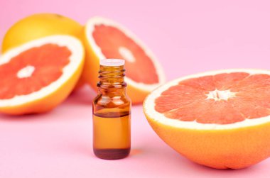 Bir şişe turunçgil yağı ve taze greyfurt..