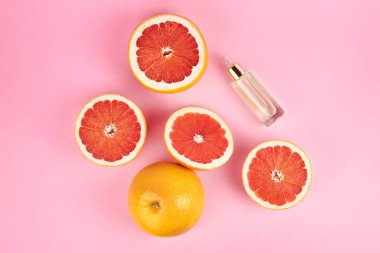 Citrus greyfurt esaslı yağ, aromaterapi veya doğal organik kozmetik düz pembe arka planda yatıyordu. Doğal vücut ve deri tedavisi.