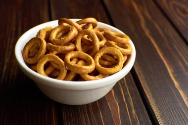 Koyu kırsal masada seramik kasede Rus simitleri.