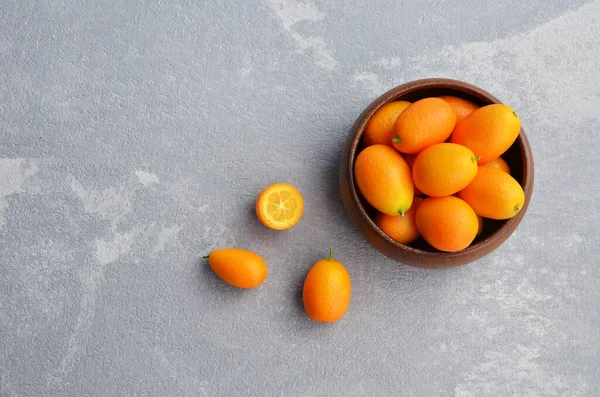 Agrumes frais kumquat fruits dans un bol en bois. Nourriture végétalienne saine. Vue de dessus. Espace de copie. — Photo