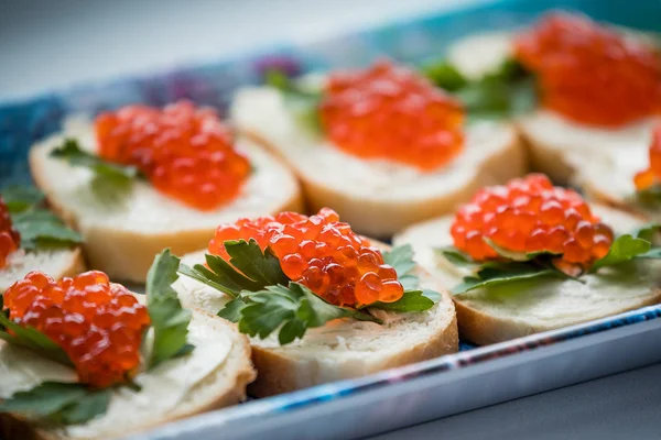 Tereyağı ve kırmızı havyar ile sandviçler. Tereyağı ve somon havyar ekmek üzerinde. Festival tablo.