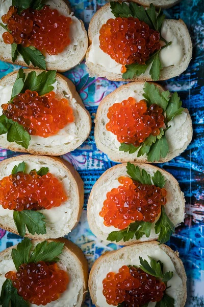 Tereyağı ve kırmızı havyar ile sandviçler. Tereyağı ve somon havyar ekmek üzerinde. Festival tablo.