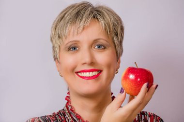 Güzel bir gülümseme ve Kırmızı elma ile bir kız. Kız ve beyaz arka plan üzerinde elma.