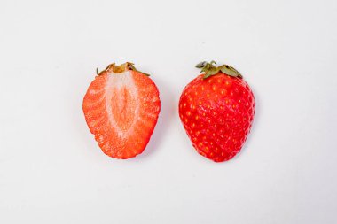 Beyaz bir arka plan üzerinde kırmızı dut dilimlenmiş.