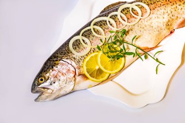 Soğan ve limon ile bir plaka üzerinde balık. Alabalık soğan halkaları ve limon ile.