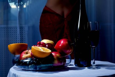 Bir bardak şarap ve meyve tabağında.