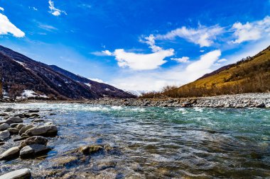 Georgia'daki dağ nehri. Hızlı akıntısı ve arka planda dağları olan bir nehir. Gürcistan Manzaraları. 