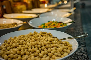 Yemeğin malzemeleri ile yemek tabakları için masada. Bezelye, sos, reçel.