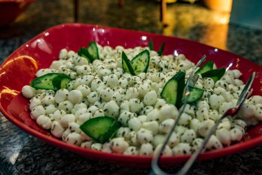 Yemek masasına yemek. Masaya sebze ve peynir dilimleme bir tabak.