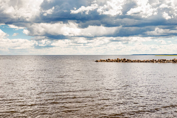 Gulf of Finland and rocks on the shore. Beautiful sky with clouds. Leningrad region, Russia.