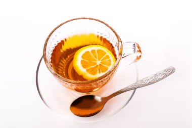 Beyaz arka plan üzerinde çay ve limon ile tabak ile Güzel şeffaf Fincan.