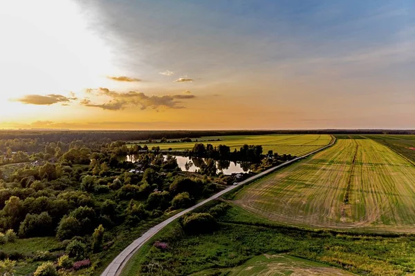 Very beautiful landscape at sunset from a bird\'s eye view. Road, lake and field. Russia.