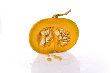 Beyaz arka plan daki balkabağı ikiye bölünür. Kabak çekirdeği.