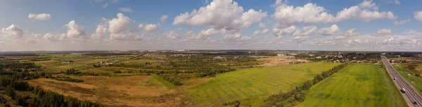 Yaz manzarasının havadan panoraması. Tarlalar, çayırlar ve yukarıda yol. Rusya, Leningrad bölgesi.
