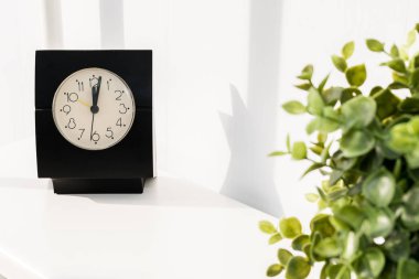 Beyaz masada saatolan bir fincan kahve. Kahve molası zamanı..