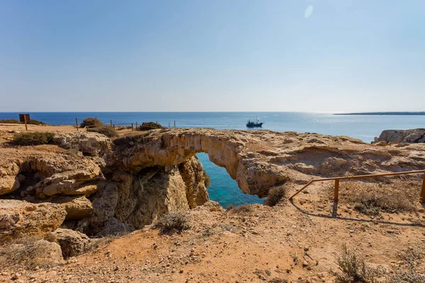 The bridge of love or love bridge. Pirate ship sailing near famous Bridge of Love near Ayia Napa, Cyprus.