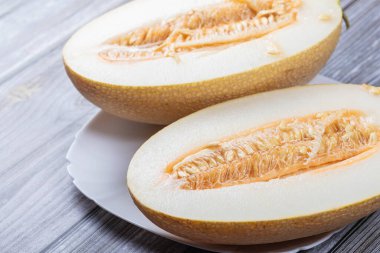 Kavun iki parçaya bölünmüş. Karpuz tohumlarına yakın çekim. Tahta masada lezzetli bir tatlı..