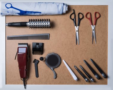 Berber aletleri beyaz çerçeveli gri bir arka plana yerleştirilir. Saç kesmek için aksesuarlar çerçevede eşit olarak düzenlenir.