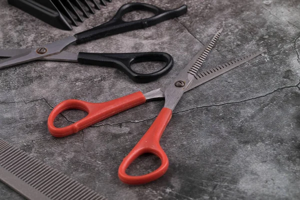 Barber tools are on the shelf in the salon. Accessories for cutting hair: scissors, combs and others are on the table.