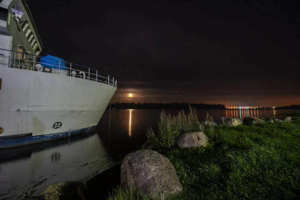 Gemi ve kıyı şeridi manzaralı gece manzarası.