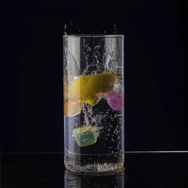 Uma Fatia Limão Cai Copo Água Fundo Preto — Fotografia de Stock