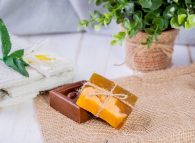 İki parça sabun, bir havlu ve beyaz bir çiçek. Spa prosedürleri..