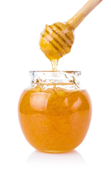Glass jar of honey and stick isolated on white background — Stock Photo, Image