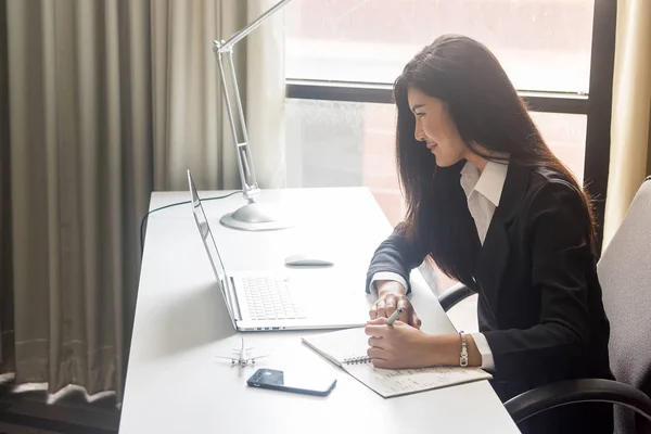 Happy business woman talking on the phone in office