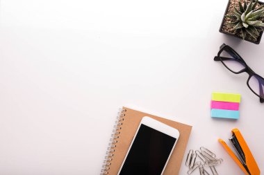 Okul aksesuarlarıyla dolu beyaz ofis masası.