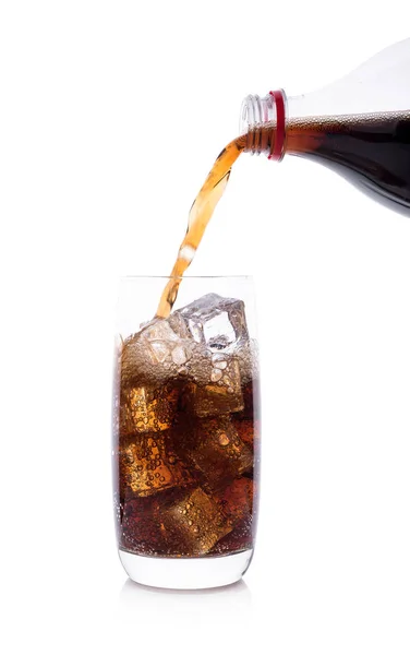 Flasche, die Cola in ein Glas mit Eiswürfeln gießt — Stockfoto