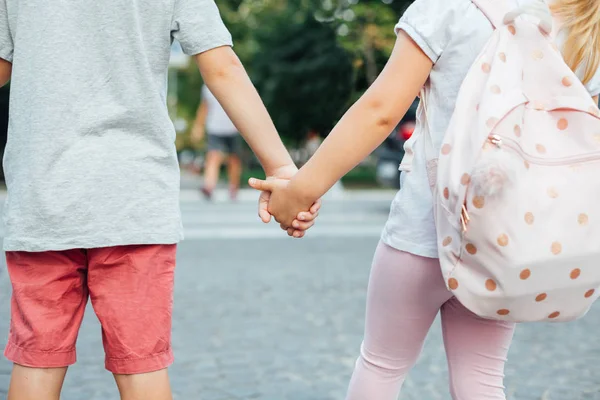 A boy and girl holding hands. Back to school.