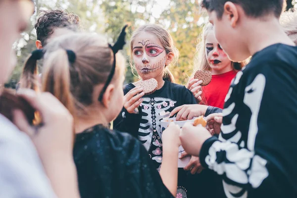 Halloween masked kids having fun in autumn park