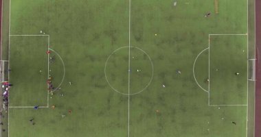 Sovyet sonrası bölgedeki futbol sahasının görünümü. Çocuklar futbol oynuyor. Hava fotoğrafçılığı.