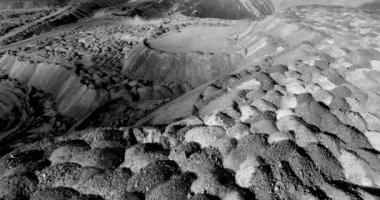 B&W. Hava fotoğrafçılığı. ağır sanayi. bir kariyer sürücüler ve toz yükseltir büyük bir damperli kamyon üst görünümü. vücut açar ve madencilik dökülür