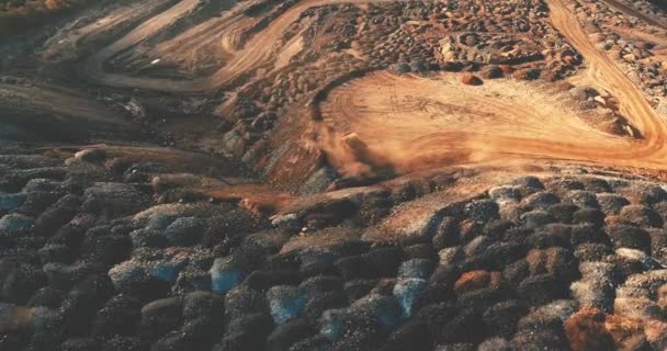 Photographie aérienne. industrie lourde. vue de dessus d'un énorme camion à benne qui conduit une carrière et soulève la poussière. ouvre le corps et renverse l'exploitation minière 