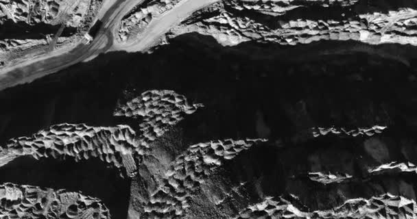 黑色和白色 航空摄影 采石场和巨大的土堆之间的蛇形 工业采石场的道路 从上面查看 巨大的卡车似乎非常小 — 图库视频影像