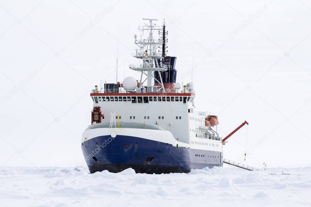 Research icebreaker docked over an ice floe in Antarctica